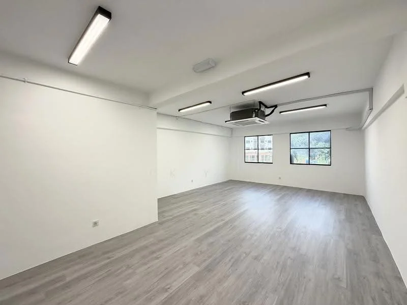 Room features: white painted walls, light grey laminate flooring, exposed ceiling with recessed LED lights, 1 wall-mounted split AC, large windows with city view, open layout; style: modern; view: city.