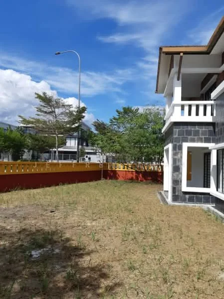 Exterior type: detached bungalow; features: two-storey building, grey stone facade, white painted balcony railings, flat roof, manicured lawn area, surrounded by greenery, red painted boundary wall, street lamp visible, driveway access, clear blue sky; style: modern.