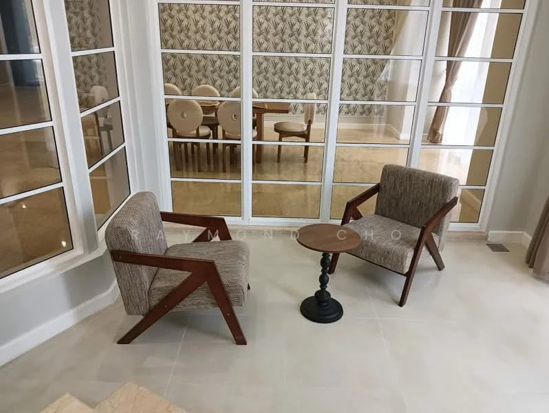 Living features: two wooden armchairs with fabric upholstery, small round side table with black base, large glass windows with white frames, cream tiled flooring, decorative wallpaper with floral pattern, curtains in neutral color, dining area visible in background with upholstered chairs; style: modern.