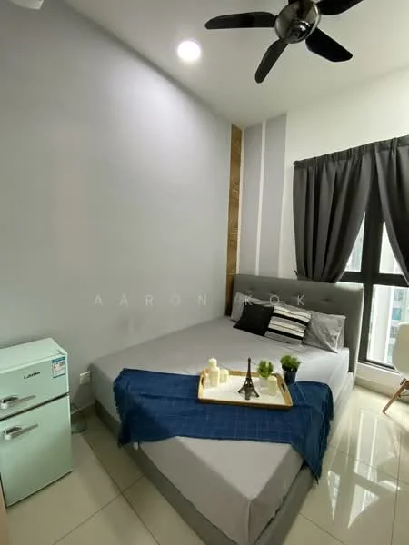 Bedroom features: queen-size bed, upholstered headboard, grey bedding, 2 bedside lamps, floor-to-ceiling window, blackout curtains, light grey painted walls, white ceiling, 5-blade ceiling fan, glossy tile flooring, small refrigerator in mint green, decorative tray with plants, decorative Eiffel Tower, study desk with chair; style: modern; view: city.