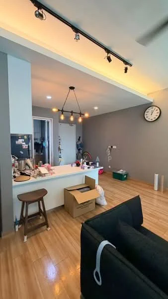 Living features: wooden flooring, grey painted walls, recessed downlights, pendant light fixture, wall clock, open kitchen layout, bar counter with stools, kitchen appliances visible, cardboard boxes, decorative items on counter; style: modern.