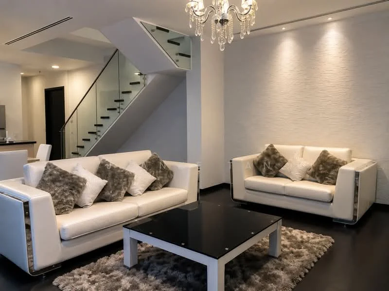 Living features: 2 white leather sofas with chrome accents, black glass coffee table, area rug with plush texture, chandelier with multiple bulbs, recessed downlights, white textured accent wall, staircase with glass railing, dark wood flooring; style: modern.