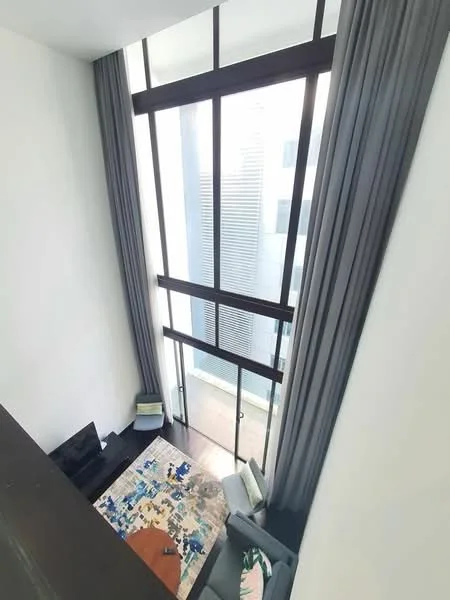 Living features: floor-to-ceiling windows, grey curtains, light wood flooring, sofa in light grey, coffee table, area rug with colorful pattern, wall-mounted TV, open space with high ceiling; style: modern; view: city.