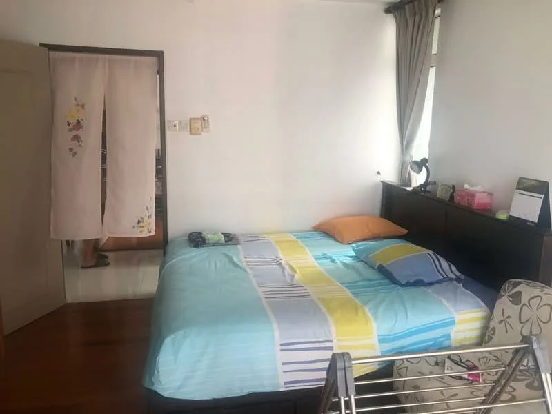 Bedroom features: queen-size bed with blue and yellow striped bedding, wooden bed frame, decorative throw pillow in orange, light wooden flooring, white painted walls, curtains in grey, nightstand with lamp, wall-mounted shelf, sliding door wardrobe, decorative chair with floral pattern; style: modern.