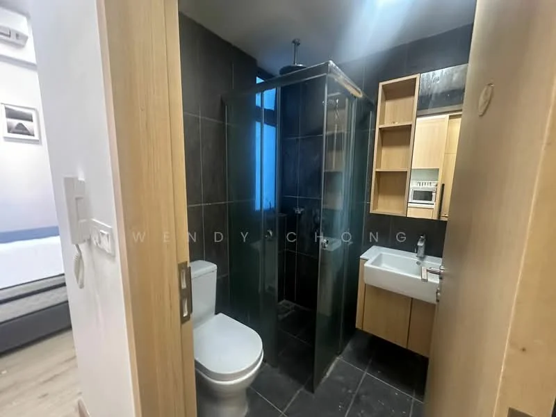 Bathroom features: black tile flooring, grey wall tiles, glass shower enclosure, single-sink vanity with wood cabinet, chrome basin mixer faucet, toilet, built-in shelving, mirror above vanity; style: modern.