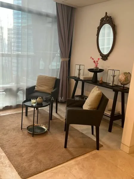 Living features: floor-to-ceiling windows, sheer curtains, light grey walls, cream area rug, two upholstered armchairs in dark fabric, small round coffee table, decorative vases, framed mirror on wall, console table, decorative globe, pink flower arrangement; style: modern; view: city.