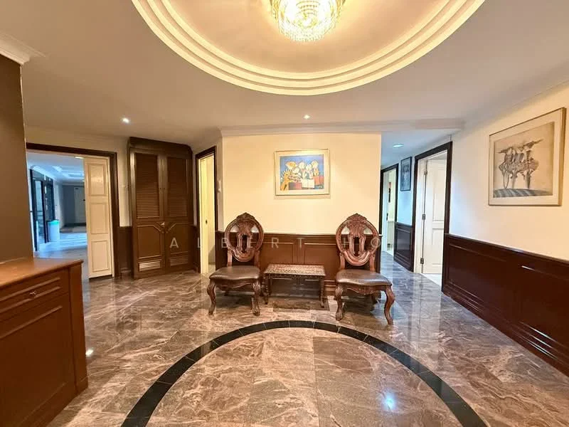 Room features: marble flooring, cream painted walls, wood paneling, crown moulding, chandelier, two carved wooden chairs, wooden side table, framed artwork on wall, recessed lighting, double doors leading to other rooms; style: traditional.