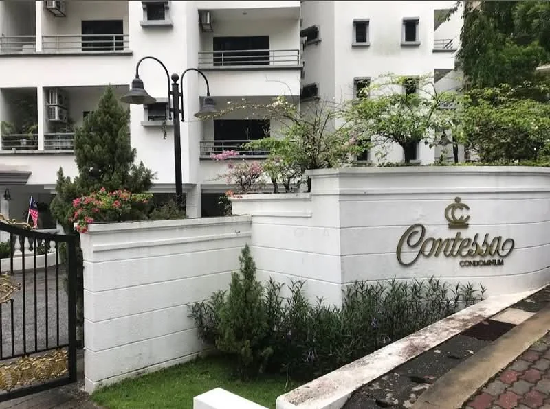 Exterior type: low-rise condominium; features: white painted facade, landscaped garden with shrubs, decorative stone wall, gated entrance, lampposts, paved driveway, visible air conditioning units, flagpole with flag, flowering plants; style: modern.