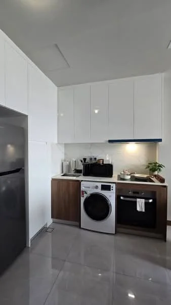 Kitchen features: white upper cabinets, wood lower cabinets, grey marble countertop, built-in oven, front-load washing machine, stainless-steel fridge, single-bowl stainless-steel sink, chrome pull-down faucet, recessed downlights, tile flooring, kitchen utensils on countertop, potted plant; style: modern.