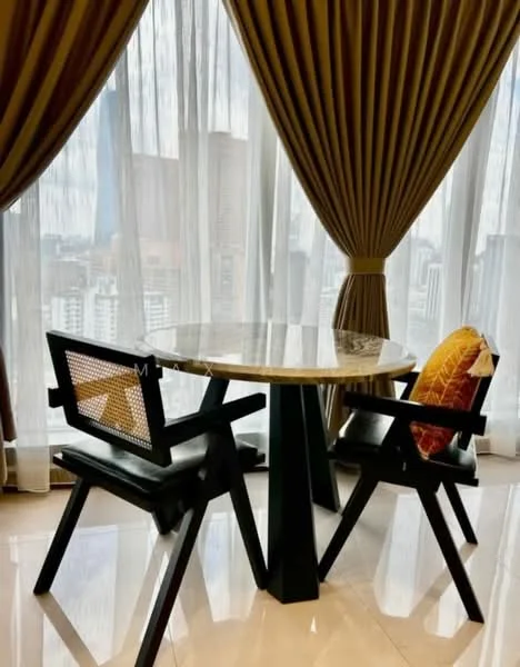 Dining features: round marble dining table, black wooden base, two black wooden chairs, woven cane backrest on chairs, decorative cushion on one chair, floor-to-ceiling windows, sheer curtains, heavy drapes, glossy tile flooring, city view; style: modern; view: city.