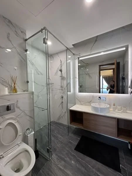 Bathroom features: glass shower enclosure, rain shower head, handheld shower, single-bowl ceramic sink, chrome basin mixer, wood vanity with storage, marble wall tiles, grey tile flooring, backlit mirror, toilet, towel rack; style: modern.