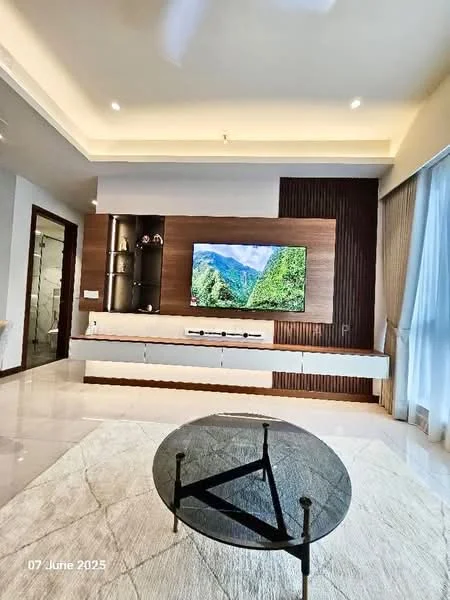 Living features: light-coloured tiled flooring, white painted walls, wood panel accent wall, built-in TV console with storage, wall-mounted flat-screen TV, large windows with sheer curtains, recessed ceiling lights, ceiling fan, round coffee table with black glass top and black metal base, area rug with neutral colour; style: modern; view: mountain.