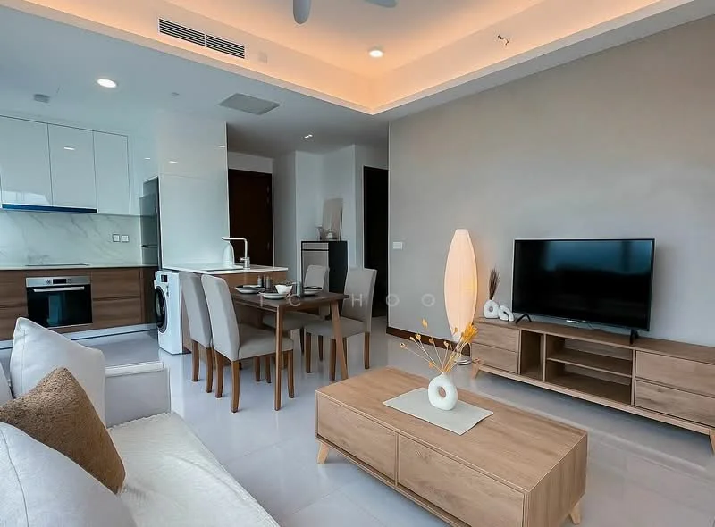 Living features: white walls, light grey accent wall, recessed ceiling with LED lighting, 5-blade ceiling fan, large window with city view, sofa with beige upholstery, wooden coffee table, TV console with storage, wall-mounted TV, dining table for four with wooden finish, chairs with upholstered seats, washer-dryer combo unit, decorative vase with branches; style: modern; view: city.