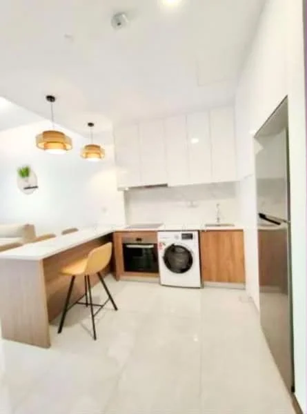 Kitchen features: white glossy cabinets, wooden lower cabinets, marble countertop, built-in oven, stainless-steel washing machine, single-bowl stainless-steel sink, chrome pull-down faucet, pendant lighting, bar stool, tile flooring, open layout, recessed downlights; style: modern.