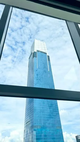 Exterior type: high-rise condominium; features: glass curtain wall, blue tinted facade, projecting roof, approximately 50-storey high-rise, surrounded by city skyline; style: modern.