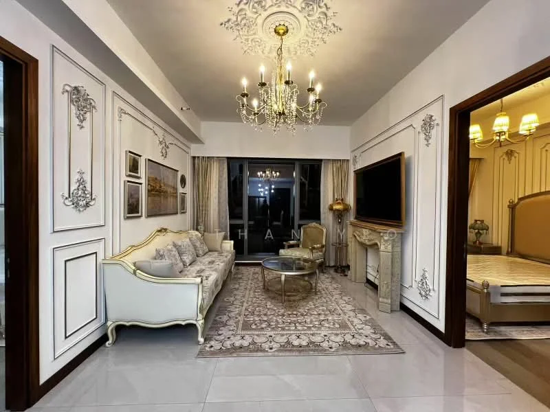 Living features: chandelier, wall-mounted TV, sofa with ornate detailing, coffee table, decorative area rug, crown moulding, white painted walls with decorative trim, floor-to-ceiling windows with sheer curtains, marble flooring, wall sconces, decorative mirror, gold accents; style: luxury.
