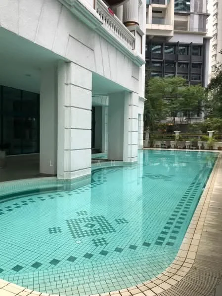 Exterior type: swimming pool deck; features: infinity pool, tiled pool deck, surrounded by landscaped greenery, modern architectural design, glass walls, decorative tiles on pool floor, poolside seating area, water feature, adjacent to building facade; style: modern.