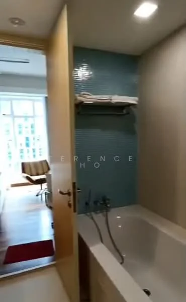 Bathroom features: bathtub, shower faucet, wall-mounted shelf, blue tile backsplash, light fixture, wooden door, flooring visible outside, window visible outside.