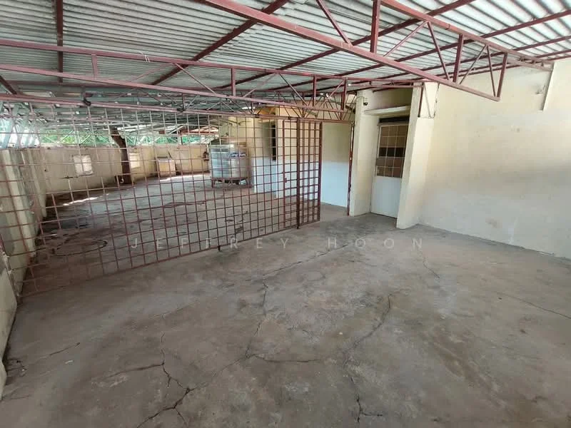 Room features: concrete flooring, exposed metal beams, metal grid partition, plain painted walls, corrugated metal roof, large open space, natural light from windows, no visible furniture; style: industrial.