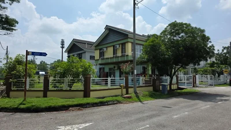 Exterior type: semi-detached house; features: two-storey structure, cream painted facade, green accents on upper level, white railings, manicured lawn, surrounding greenery, fenced yard, driveway, street view, corner lot, electricity poles visible, road signage; style: modern.