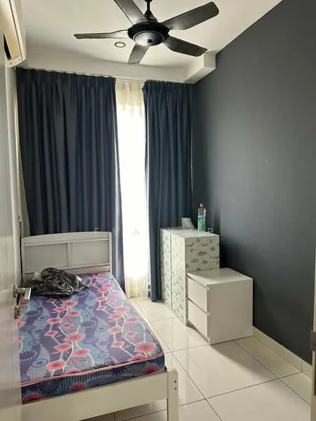 Bedroom features: single bed with patterned bedding, white wooden bed frame, dark blue accent wall, light grey walls, floor-to-ceiling window with sheer curtains, ceiling fan with 5 blades, white bedside table, white storage cabinet, tile flooring, water bottle on cabinet, clothing on bed; style: modern.