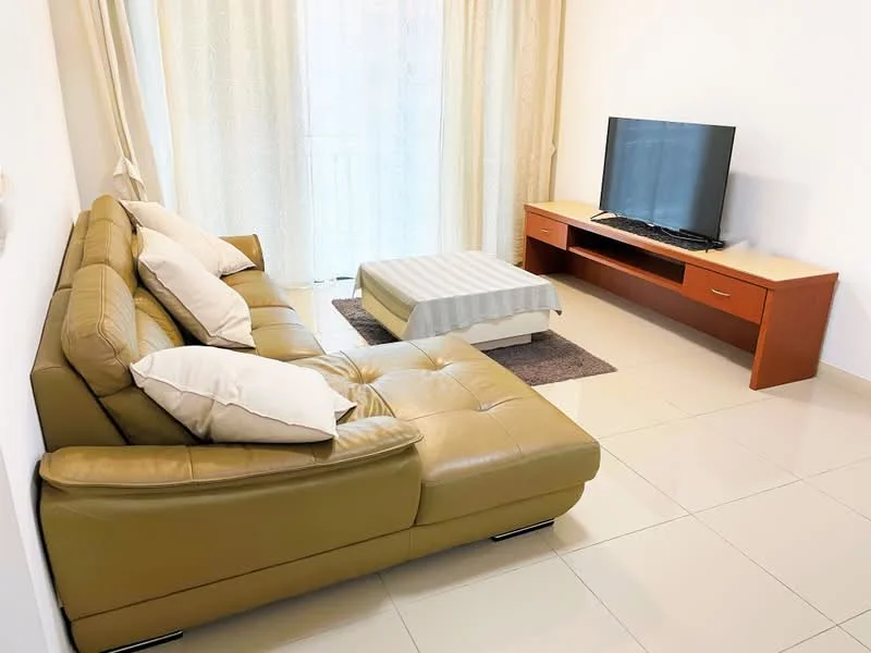 Living features: L-shape sectional sofa in beige leather, decorative cushions, coffee table with light grey fabric, TV console in wood finish, wall-mounted flat-screen TV, light-coloured curtains, white painted walls, glossy tile flooring, area rug in neutral tones; style: modern.