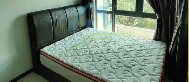 Bedroom features: queen-size bed, upholstered headboard in black, white mattress with heart pattern, floor-to-ceiling windows, blackout curtains, light grey walls, tile flooring, natural light from window; style: modern; view: garden.