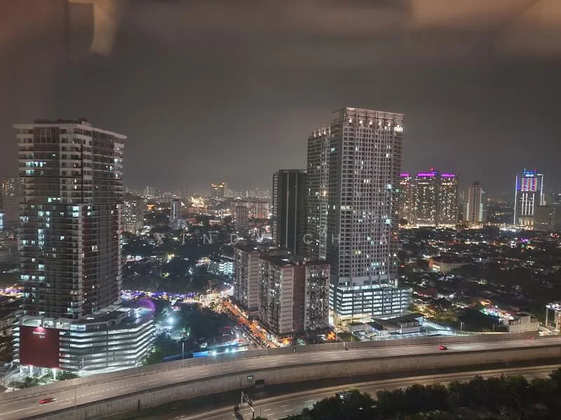 Exterior type: high-rise condominium; features: city skyline view, multiple high-rise buildings, night lighting, urban landscape, highway visible in foreground; style: modern.