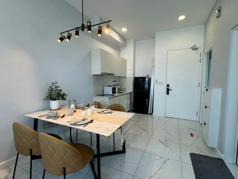 Dining features: marble tile flooring, white painted walls, dining table with marble top, 2 upholstered dining chairs in beige, pendant light fixture with multiple bulbs, wall-mounted refrigerator, built-in kitchen cabinets, countertop with kitchen appliances, open layout to kitchen area, door leading to hallway; style: modern. Kitchen features: white cabinetry, black refrigerator, microwave on countertop, kitchen sink, countertop space, stainless-steel appliances; style: modern.
