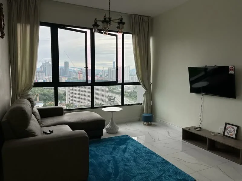 Living features: grey fabric L-shape sectional sofa, white round coffee table, blue area rug, wall-mounted flat-screen TV, wooden TV console, floor-to-ceiling windows, curtains, city skyline view, marble tile flooring, chandelier with multiple bulbs; style: modern; view: city.