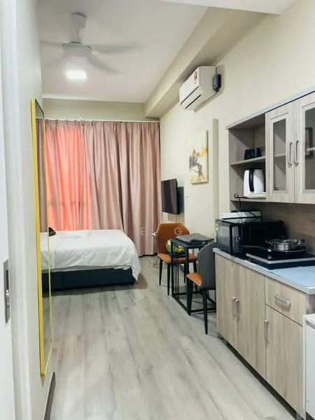 Room features: wooden flooring, white painted walls, ceiling fan, wall-mounted split AC, floor-to-ceiling window with sheer curtains, double bed with white bedding, TV mounted on wall, dining table with two chairs, kitchenette with cabinets, microwave, electric kettle, stainless-steel cooking pot, countertop, framed artwork on wall, decorative mirror; style: modern.