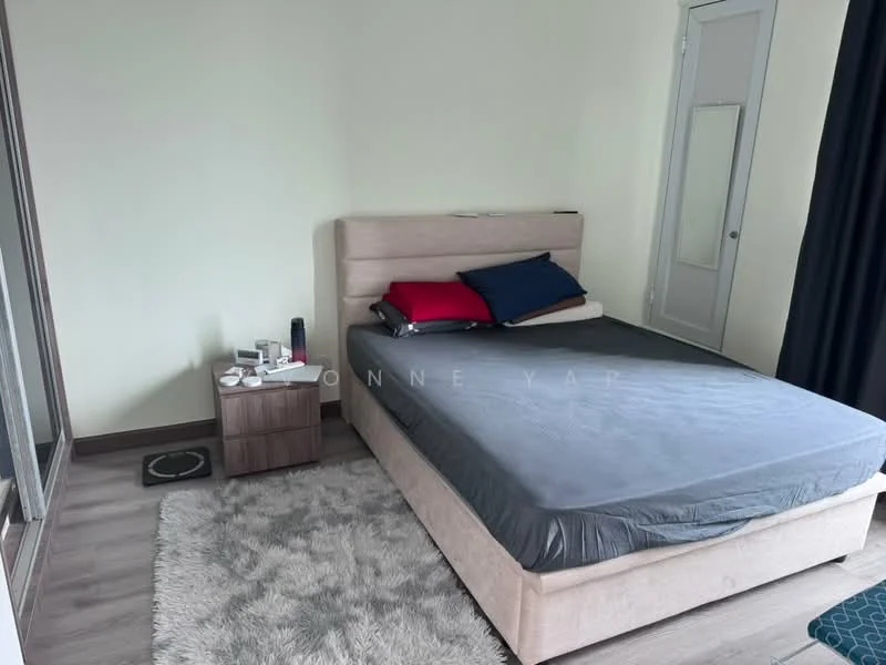 Bedroom features: queen-size bed with grey bedding, upholstered headboard, two decorative pillows in red and blue, nightstand with drawer, table lamp, area rug with fluffy texture, wooden flooring, floor-to-ceiling window, blackout curtains, white painted walls; style: modern.