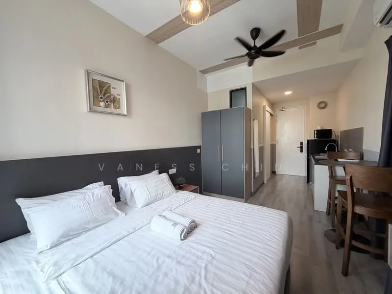 Bedroom features: queen-size bed with white bedding, wooden headboard, 2 bedside pillows, ceiling fan, recessed downlights, wooden flooring, framed artwork on wall, built-in wardrobe, study desk with chair, kitchenette with microwave, wall-mounted TV, door to hallway; style: modern.