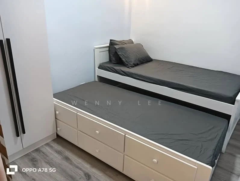 Bedroom features: single bed with grey bedding, pull-out bed underneath, white wooden bed frame, built-in wardrobe with sliding doors, grey laminate flooring, white walls, natural light from window, minimalist decor; style: modern.