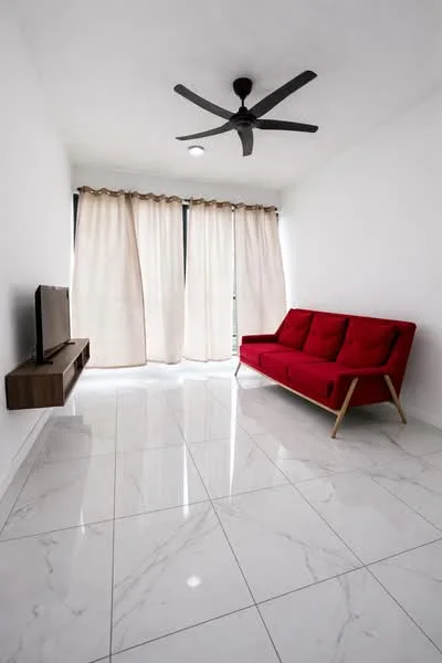 Living features: red fabric sofa, wall-mounted TV, white painted walls, marble tile flooring, 5-blade ceiling fan with light, floor-to-ceiling windows, sheer curtains, wooden TV console; style: modern.