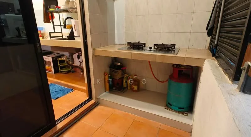 Kitchen features: gas stove with two burners, kitchen countertop, green gas cylinder, white tiled walls, orange tiled flooring, open shelving, kitchen sink, window with security bars.