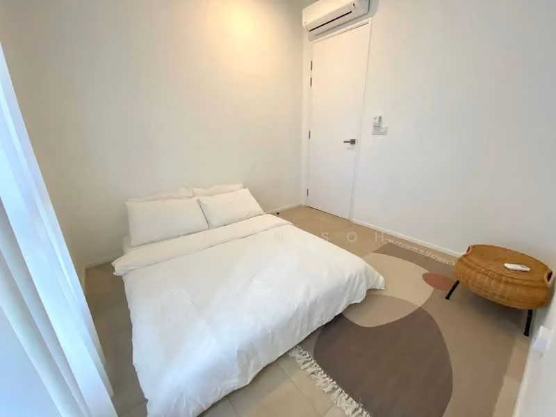 Room features: white painted walls, tile flooring, 1 wall-mounted split AC, floor rug with abstract pattern, bed with white bedding, woven accent chair, door with handle, light switch; style: minimalist.