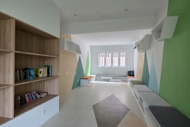 Room features: built-in wooden shelving with books, geometric wall design in green, beige, and white, large windows with horizontal blinds, light-colored flooring, seating area with cushions in various colors, recessed ceiling lights, air conditioning unit on the wall, open layout; style: modern.