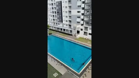 Exterior type: mid-rise condominium; features: swimming pool, pool deck with loungers, manicured lawn, surrounded by greenery, modern facade with grey and white colors, balconies visible on upper floors; style: modern.
