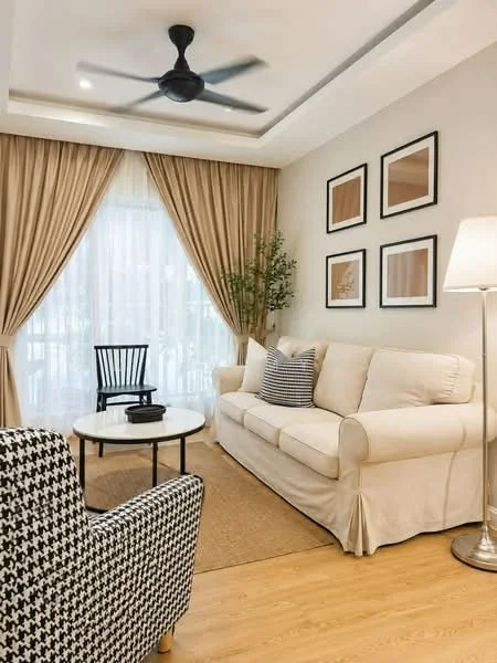 Living features: 3-seater fabric sofa in cream, black and white patterned armchair, round coffee table, area rug, floor lamp, 5-blade ceiling fan, curtains with sheer and blackout layers, decorative wall art, wooden chair, plant in pot, wooden flooring, crown moulding on ceiling; style: modern.