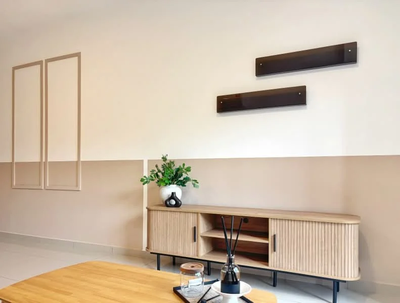 Living features: light beige painted walls, dark beige painted accent wall, wooden console table with open shelving, decorative plant in a black vase, decorative wall shelves, ceramic diffuser, glass container on table, wooden coffee table, white tiled flooring; style: modern.