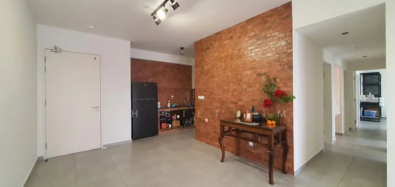 Living features: exposed brick accent wall, white painted walls, grey tile flooring, recessed downlights, black fridge, wooden console table, decorative flowers on table, open layout, kitchen area visible, doorway to other rooms; style: modern.