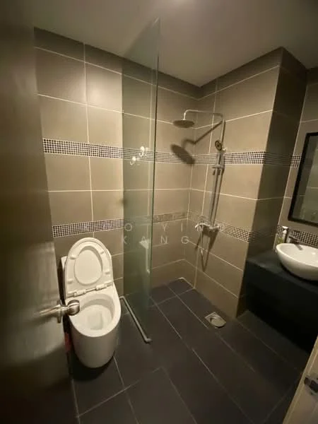Bathroom features: grey tiled walls, dark grey floor tiles, walk-in shower with glass enclosure, rain shower head, handheld shower, chrome shower valve, one-piece toilet, wall-mounted sink, framed mirror, tile accent strip, drain in floor; style: modern.