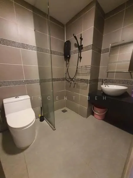 Bathroom features: walk-in shower with glass enclosure, chrome handheld shower, wall-mounted shower head, single-sink vanity with round basin, white toilet, grey ceramic tile flooring, grey tiled walls with decorative border, mirror above sink, towel rack, pink storage bin; style: modern.