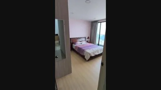 Bedroom features: queen-size bed, wooden bed frame, bedside lamps, floor-to-ceiling windows, curtains, light wood flooring, pink painted walls, decorative wall mirror; style: modern; view: city.