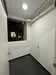 Room features: white painted walls, black flooring, ceiling light, window, air conditioning unit.