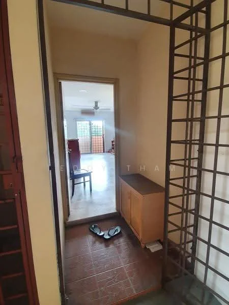 Room features: tile flooring, cream painted walls, wooden cabinet, sliding door, ceiling fan, open space leading to another room, doorway, shoe rack, slippers on the floor.