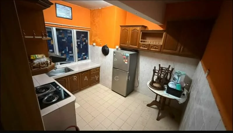 Kitchen features: orange painted walls, white tiled backsplash, laminate cabinetry in brown, single-bowl stainless-steel sink, chrome pull-down faucet, built-in gas hob with 2 burners, freestanding fridge, ceramic tile flooring, window with patterned glass, wooden dining table, stool, kitchen utensils on countertop.