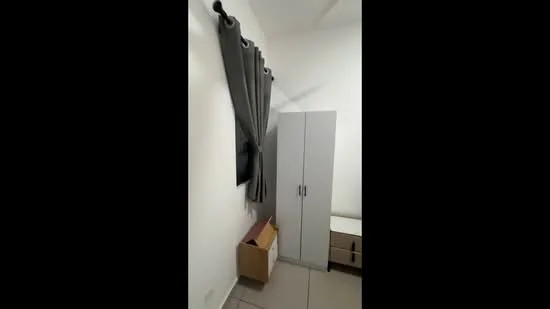 Room features: grey curtains, white walls, light-colored flooring, built-in wardrobe with sliding doors, TV mounted on the wall, small side table, box storage, minimalist decor; style: modern.