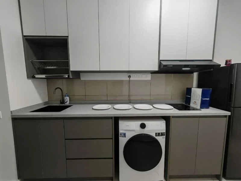 Kitchen features: grey laminate cabinetry, white upper cabinets, black single-bowl stainless-steel sink, chrome pull-down faucet, grey quartz countertop, built-in stove, front-load washing machine, black refrigerator, four white plates on countertop, wall-mounted range hood, tile backsplash, under-cabinet lighting; style: modern.